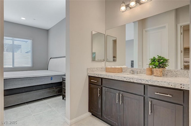 bathroom with tile patterned floors, vanity, and baseboards