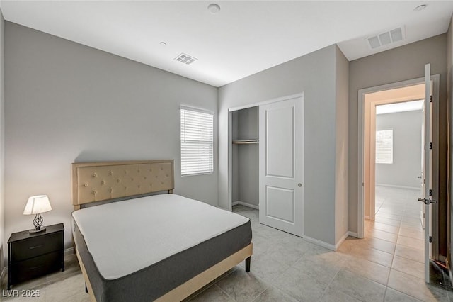 bedroom with a closet, visible vents, and baseboards