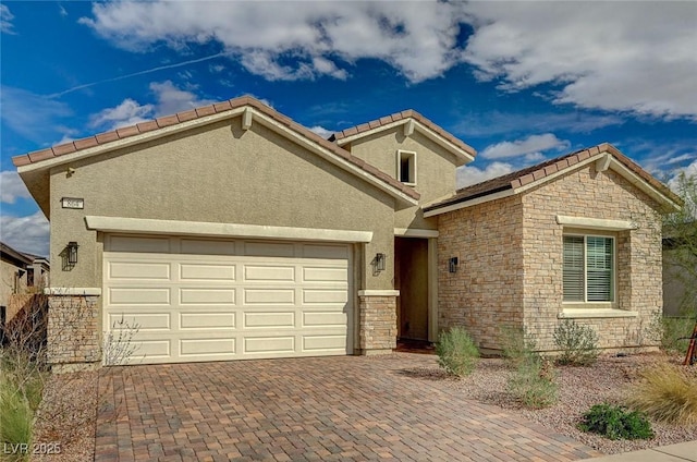 view of front facade with stucco siding, a tile roof, decorative driveway, stone siding, and an attached garage