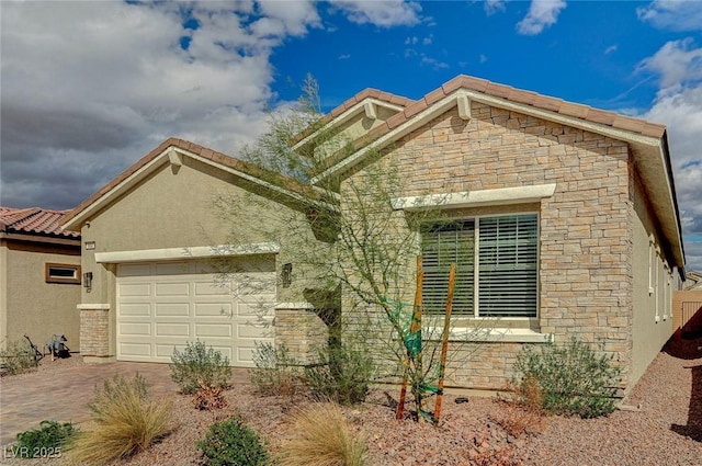 craftsman house with stucco siding, decorative driveway, stone siding, a garage, and a tiled roof