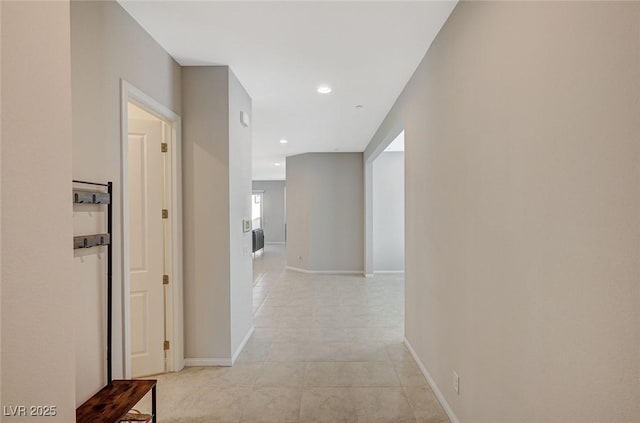 hall featuring light tile patterned floors, recessed lighting, and baseboards