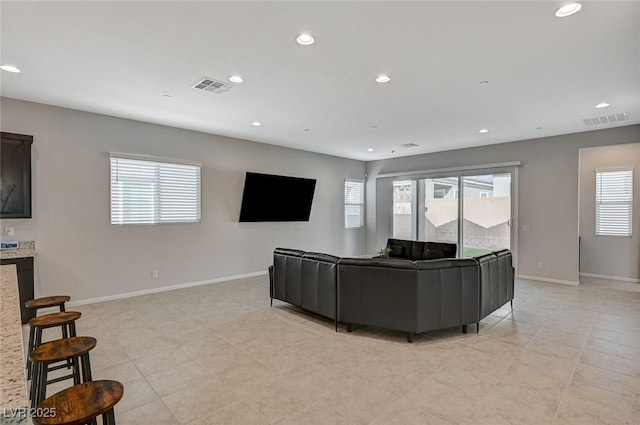 living area with recessed lighting, visible vents, and baseboards