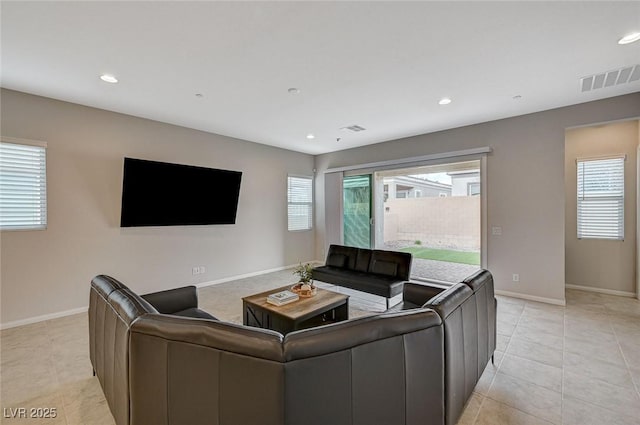 living room featuring recessed lighting, baseboards, and plenty of natural light