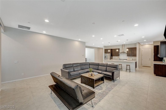 living area with visible vents, recessed lighting, and baseboards