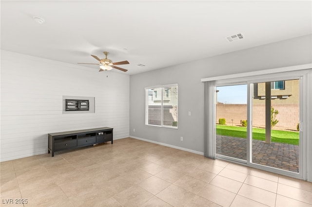 living area featuring light tile patterned floors, visible vents, baseboards, and a ceiling fan