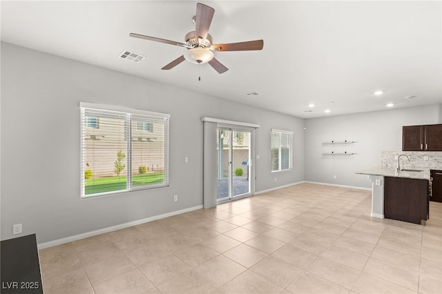 unfurnished living room with a ceiling fan, baseboards, visible vents, recessed lighting, and a sink