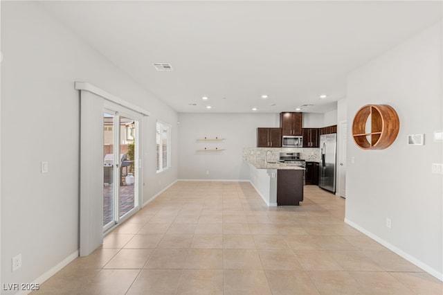 kitchen featuring tasteful backsplash, visible vents, dark brown cabinetry, light tile patterned flooring, and stainless steel appliances