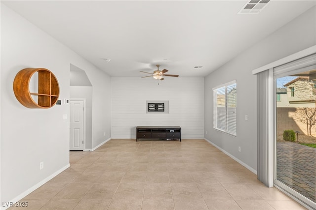 unfurnished living room featuring light tile patterned flooring, visible vents, ceiling fan, and baseboards