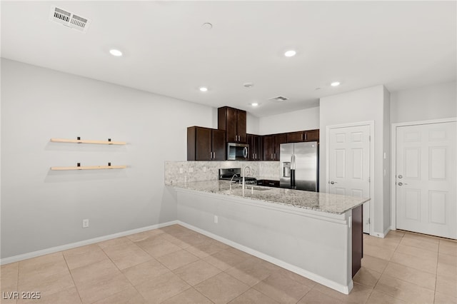 kitchen featuring tasteful backsplash, visible vents, dark brown cabinetry, appliances with stainless steel finishes, and a sink