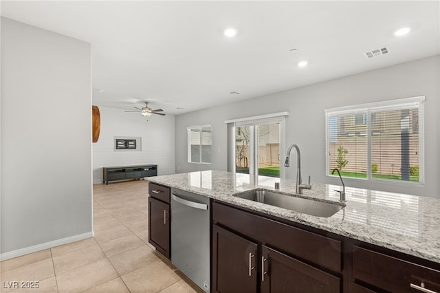 kitchen with visible vents, a sink, light tile patterned flooring, light stone countertops, and dishwasher