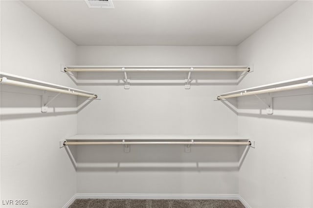 walk in closet featuring visible vents and carpet flooring