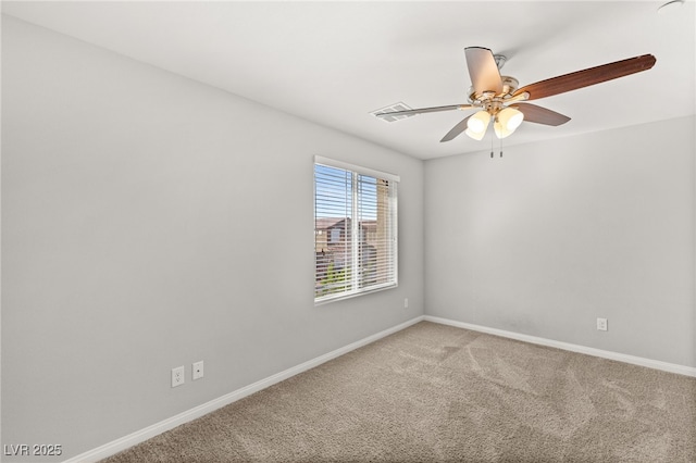 carpeted spare room featuring baseboards and a ceiling fan