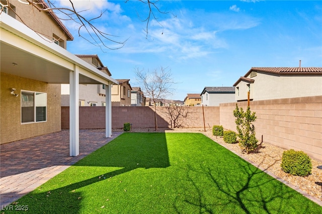 view of yard featuring a patio area, a residential view, and a fenced backyard