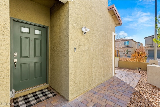 view of exterior entry featuring stucco siding