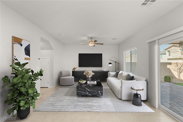 tiled living room featuring a ceiling fan and visible vents