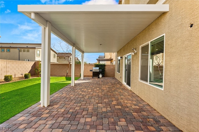 view of patio with fence and a grill