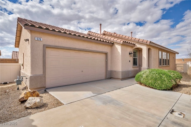 mediterranean / spanish home with stucco siding, driveway, a garage, and fence