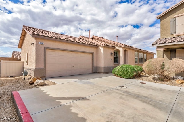 mediterranean / spanish-style house with stucco siding, a tiled roof, concrete driveway, and a garage