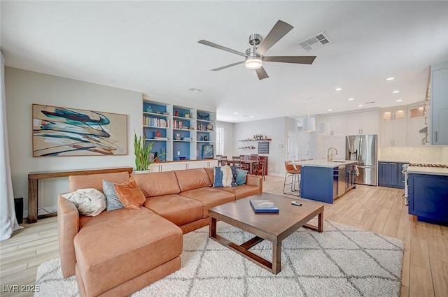 living area featuring recessed lighting, visible vents, light wood-style floors, and a ceiling fan