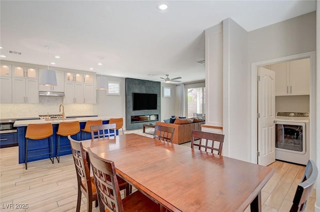 dining room featuring light wood-type flooring, visible vents, recessed lighting, washer / dryer, and ceiling fan