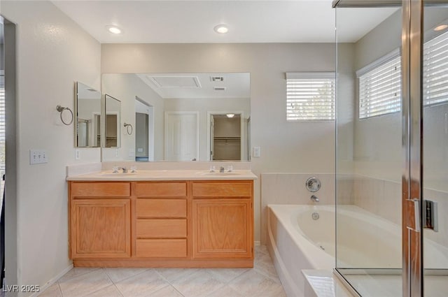 bathroom with tile patterned flooring, double vanity, a bath, and a sink