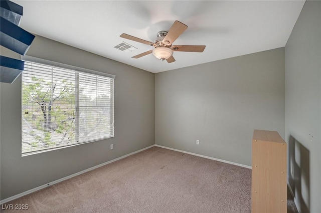 unfurnished room with a ceiling fan, visible vents, carpet floors, and baseboards