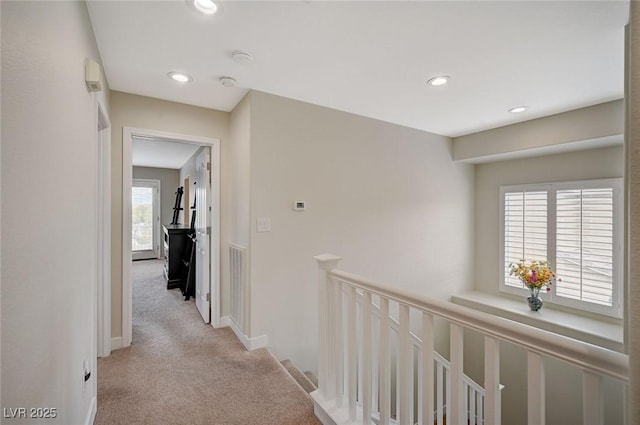 corridor featuring light carpet, an upstairs landing, recessed lighting, and baseboards