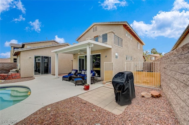 rear view of property with stucco siding, a patio, a ceiling fan, and fence