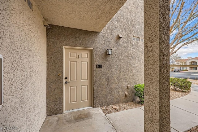 property entrance with stucco siding