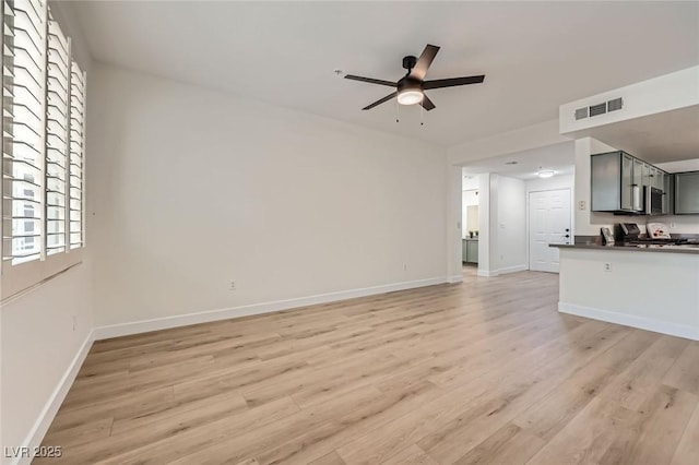 unfurnished living room featuring baseboards, a ceiling fan, visible vents, and light wood-type flooring