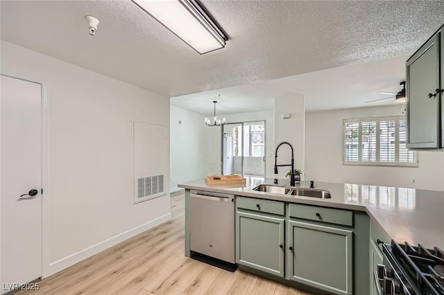 kitchen featuring range, dishwasher, green cabinets, and a sink