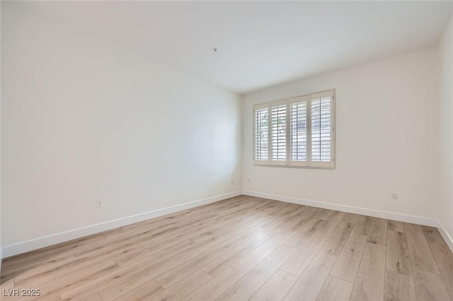 unfurnished room with light wood-type flooring and baseboards