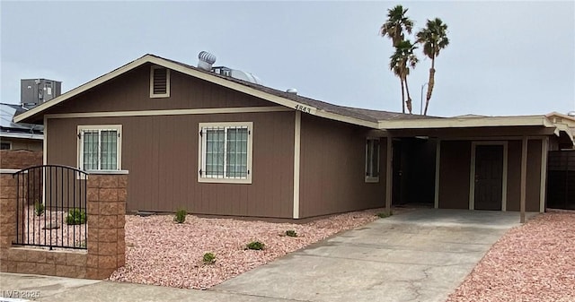 single story home featuring fence, a carport, concrete driveway, and a gate