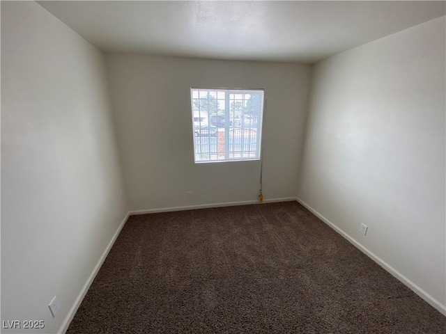 unfurnished room with carpet flooring and baseboards