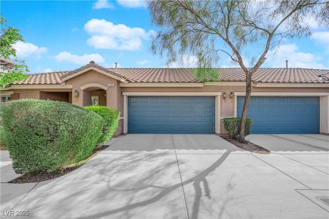 view of front of property featuring a tile roof, stucco siding, an attached garage, and concrete driveway