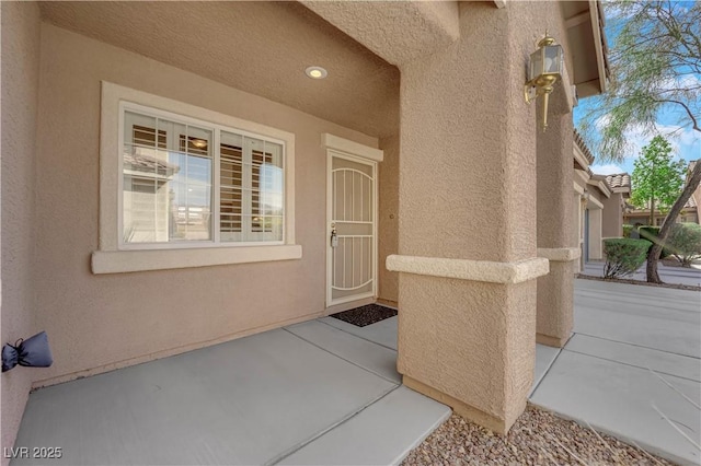 doorway to property with stucco siding, a tiled roof, and a patio