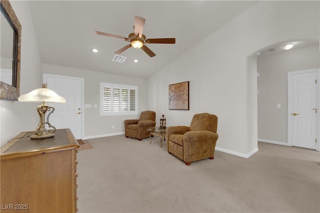 living area featuring visible vents, arched walkways, carpet floors, ceiling fan, and vaulted ceiling