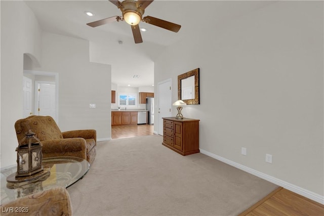 living area featuring a ceiling fan, recessed lighting, arched walkways, baseboards, and vaulted ceiling