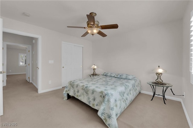 bedroom with a ceiling fan, baseboards, a closet, and light carpet