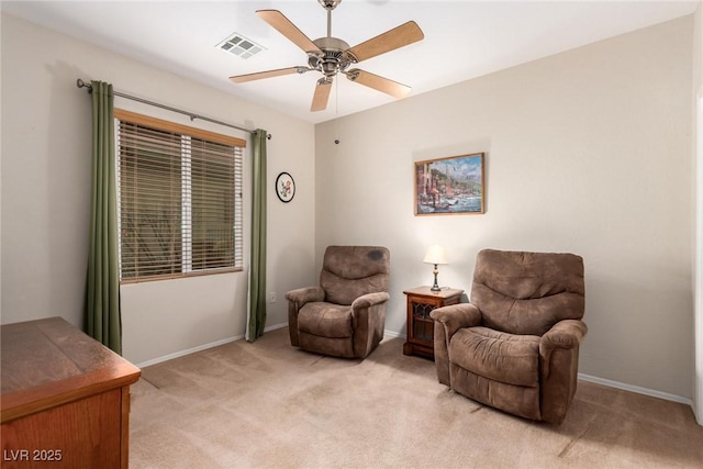 sitting room with visible vents, light colored carpet, baseboards, and a ceiling fan