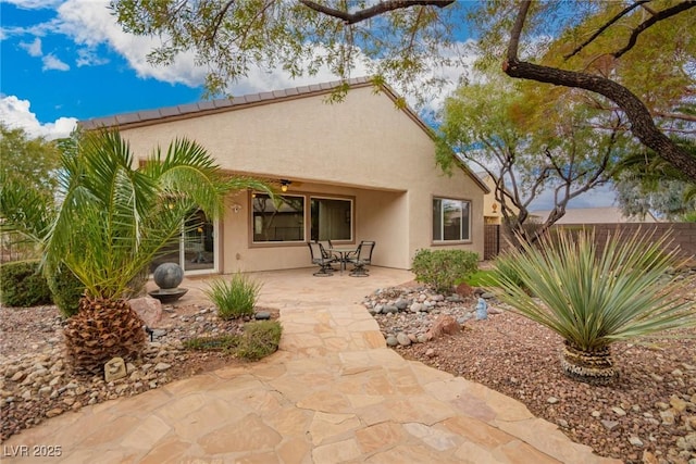 back of house with stucco siding, ceiling fan, and a patio area