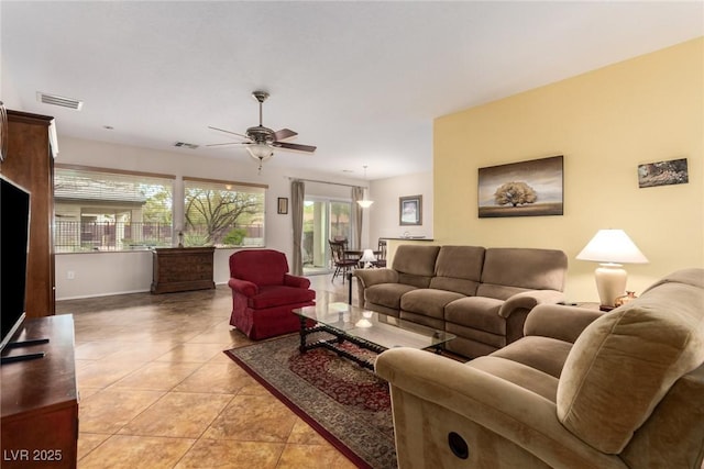 living room featuring light tile patterned floors, visible vents, and ceiling fan