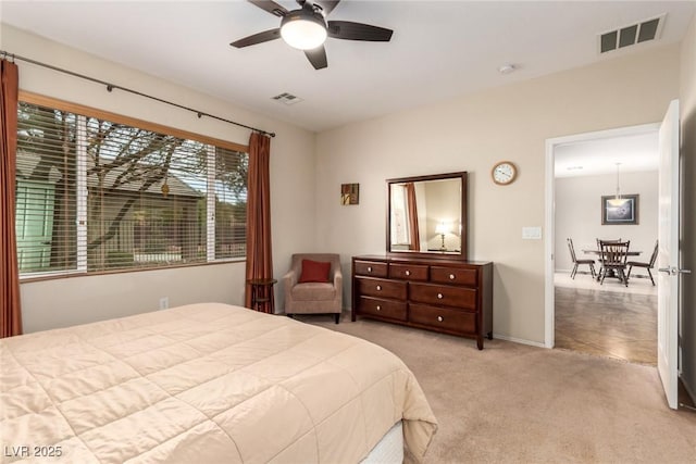 bedroom featuring a ceiling fan, baseboards, visible vents, and light carpet