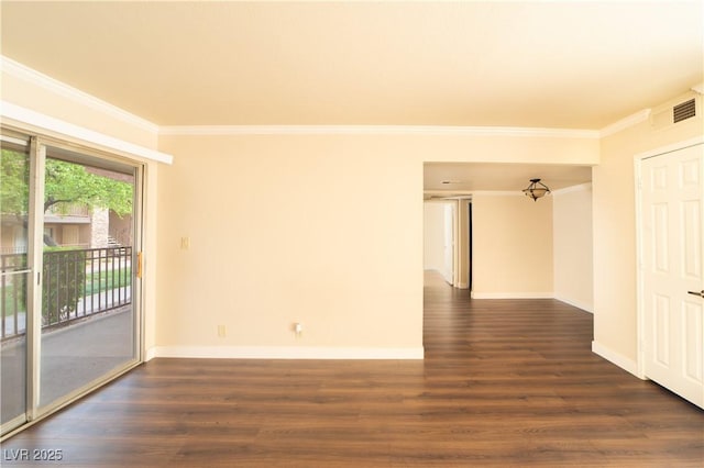 empty room with visible vents, baseboards, wood finished floors, and crown molding