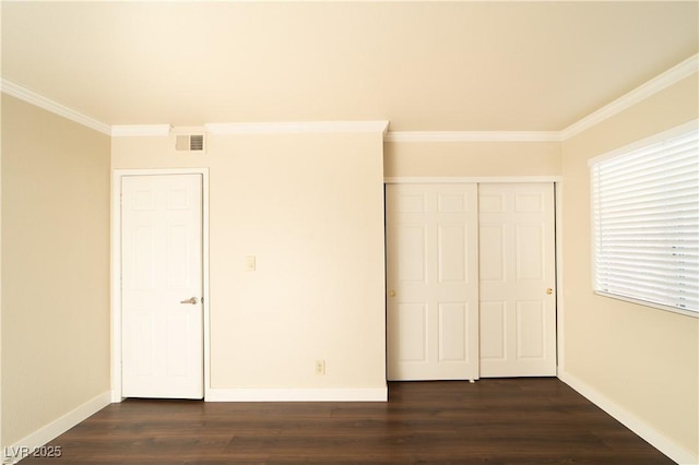 unfurnished bedroom with crown molding, dark wood-style floors, visible vents, and baseboards