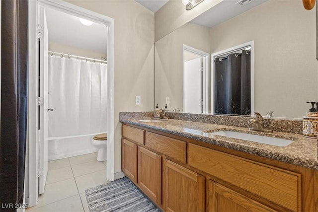 full bathroom with a sink, toilet, double vanity, and tile patterned floors