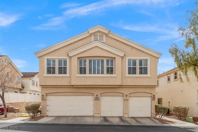 view of front facade featuring concrete driveway, fence, a garage, and stucco siding