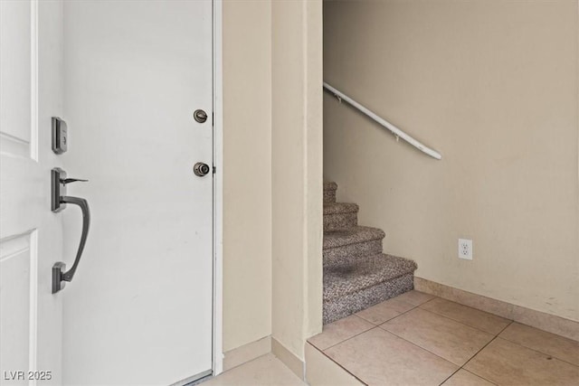 stairs with tile patterned floors and baseboards