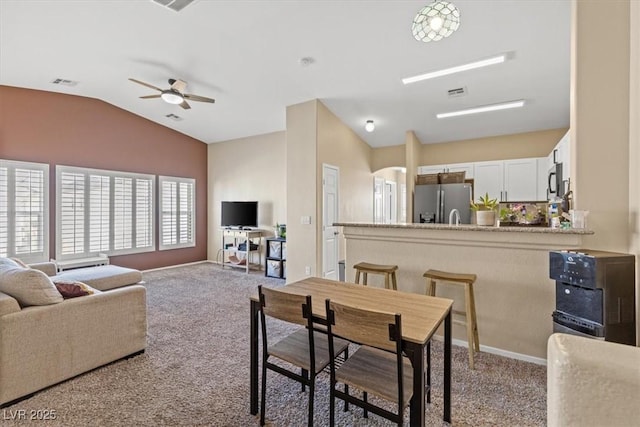 dining area with carpet flooring, visible vents, lofted ceiling, and ceiling fan