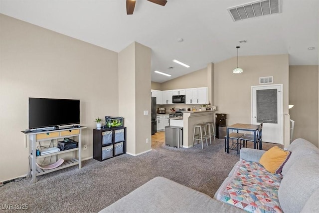 living room featuring visible vents, lofted ceiling, light colored carpet, and a ceiling fan